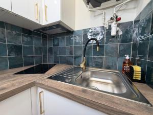 a kitchen with a stainless steel sink in a kitchen at Studio moderne climatisé - Parking gratuit - Paris & Disney in Ormesson-sur-Marne