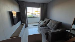 a living room with a couch and a window at Apartamento 2 quartos com ar-condicionado, Wi-Fi e Netflix in Americana