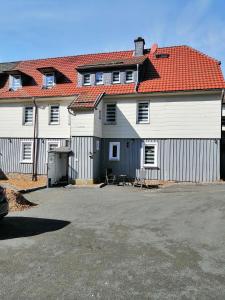 a large white building with a red roof at Gästehaus an der Bode wahlweise mit Halbpension PLUS in Braunlage