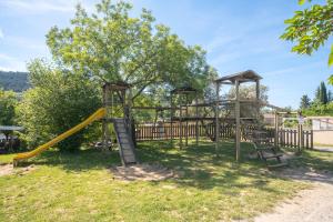 a playground in a park with a slide at Ludocamping in Lussas