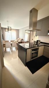 a kitchen and living room with a stove top oven at Apartamento 2 quartos com ar-condicionado, Wi-Fi e Netflix in Americana