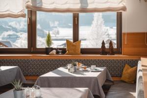 a restaurant with two tables in front of a window at Hotel Lipeter & Bergheimat in Weissensee