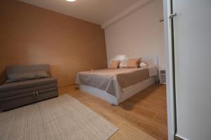 a bedroom with a bed and a chair at Apartment Sanja in Zadar