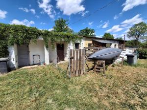 a house with a boat next to a fence at Mazurska przystań 2 in Gąsiorowo Olsztyneckie