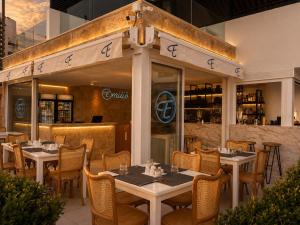 a restaurant with tables and chairs in front of a building at Gondola Marine Resort in Ḩālāt