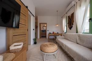 a living room with a couch and a tv at Asini deluxe suite 5, with rooftop terrace and breathtaking views in Asíni