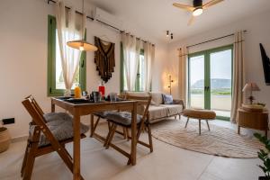 a living room with a table and chairs and a couch at Asini deluxe suite 5, with rooftop terrace and breathtaking views in Asíni