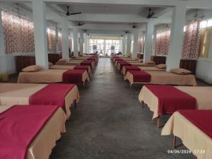 a row of beds in a large room at Adharshila hotel & Dormitory in Shahdol +5 photos