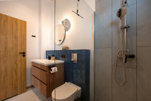 a bathroom with a shower and a toilet and a sink at Asini deluxe suite 5, with rooftop terrace and breathtaking views in Asíni +53 photos