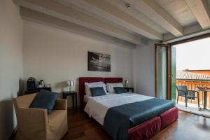 a bedroom with a bed and a chair and a window at Hotel Del Porto in Torri del Benaco +75 photos