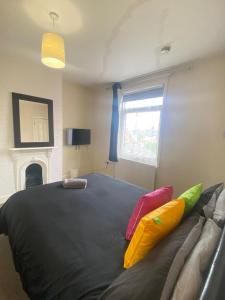 a bedroom with a large black bed with colorful pillows at 4-5 Bedroom House For Corporate Stays in Kettering in Kettering