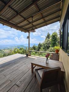 a wooden deck with a bench and a table at U Garden in Ban Huai Khai