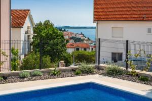 a swimming pool in front of a house at Villa Cvita west in Primošten