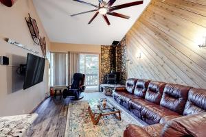 a living room with a leather couch and a television at Crestview 48 in Mammoth Lakes