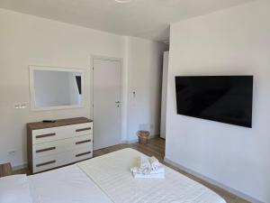 a bedroom with a bed and a dresser and a television at Guest House Tra Rocce E Mare in La Maddalena