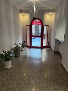 a hallway with a red door and potted plants at Hotel CHG LEYTON in Foz +12 photos