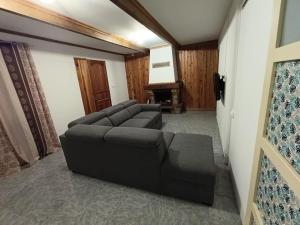 a living room with a black couch and a television at La grande découverte 2 in Cilaos