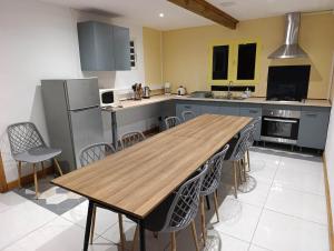 a kitchen with a wooden table and chairs at La grande découverte 2 in Cilaos