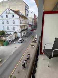 a balcony of a building with chairs and a street at Hotel CHG LEYTON in Foz