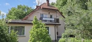 a house with a balcony on top of it at Lipowy Dworek Pensjonat in Staroguby