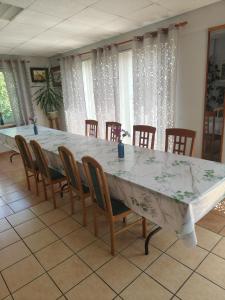 a large table and chairs in a room with curtains at Lipowy Dworek Pensjonat in Staroguby