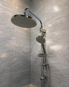 a shower with a shower head in a bathroom at Lindi Premium Hotel in Prizren