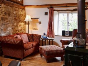 a living room with a couch and a chair at The Old Barn in Abbotsham