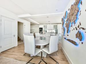 a white dining room with a white table and white chairs at The Beach House in Worthing