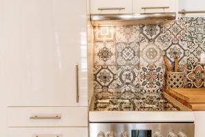 a kitchen with an ornate tile wall at Alkyoni Samos Maisonette in Mytilinioí +23 photos