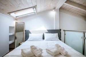 a bedroom with a bed with white sheets and pillows at Alkyoni Samos Maisonette in Mytilinioí