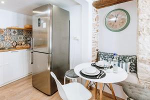 a small kitchen with a table and a refrigerator at Alkyoni Samos Maisonette in Mytilinioí