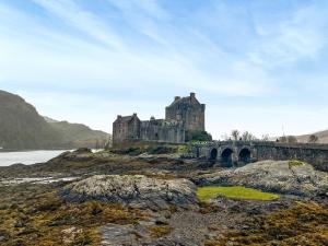 a castle on a hill with a bridge and water at Duich - Uk50716 in Kirkton