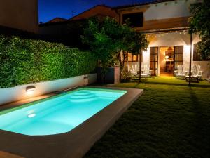 a swimming pool in the yard of a house at night at La Casa del Jardín in Candeleda