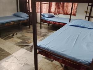 three bunk beds in a room with a floor at CK Enclave in Tripunittura +2 photos