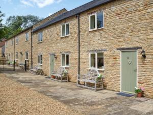 a brick building with benches in front of it at Lily Pad 7 - Uk43916 in Nassington +19 photos