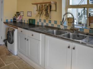 a kitchen with a sink and a washing machine at Lily Pad 9 - Uk43919 in Nassington