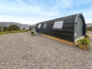 a black clad tiny house on a gravel driveway at Totaig - Uk50717 in Kirkton