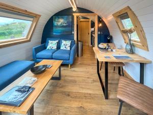 a tiny house with a blue couch and a table at Totaig - Uk50717 in Kirkton +8 photos