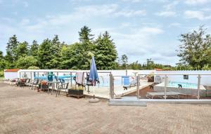 a patio with a swimming pool and a swimming house at One-Bedroom Apartment In Ebeltoft in Ebeltoft