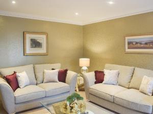 a living room with two couches and a table at Tennox Farm House - Uk36254 in Kilbirnie