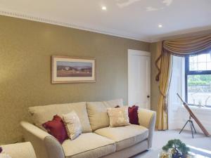 a living room with a couch and a window at Tennox Farm House - Uk36254 in Kilbirnie