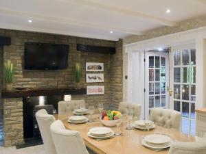 a dining room with a table and chairs and a television at Tennox Farm House - Uk36254 in Kilbirnie