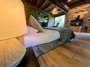 a bedroom with a bed and a stone wall at CABAÑA SUITE Deluxe in A Pontenova +22 photos