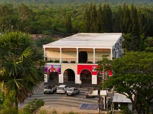 a building with cars parked in a parking lot at Aanya Taara Resort- Mettupalayam in Mettuppālaiyam