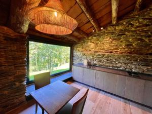 a dining room with a table and a large window at CABAÑA SUITE Deluxe in A Pontenova