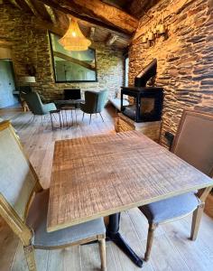 a wooden table and chairs in a room with a fireplace at CABAÑA SUITE Deluxe in A Pontenova