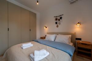 a bedroom with a bed with towels on it at Asini deluxe suite 6, with rooftop terrace and breathtaking views in Asíni
