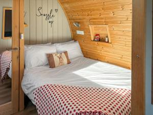 a bed in a room with a wooden wall at The Welbury - Ukc9285 in Brompton