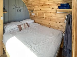 a bed in a room with a wooden wall at The Welbury - Ukc9285 in Brompton