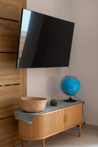 a flat screen tv on top of a wooden stand at Asini deluxe suite 6, with rooftop terrace and breathtaking views in Asíni